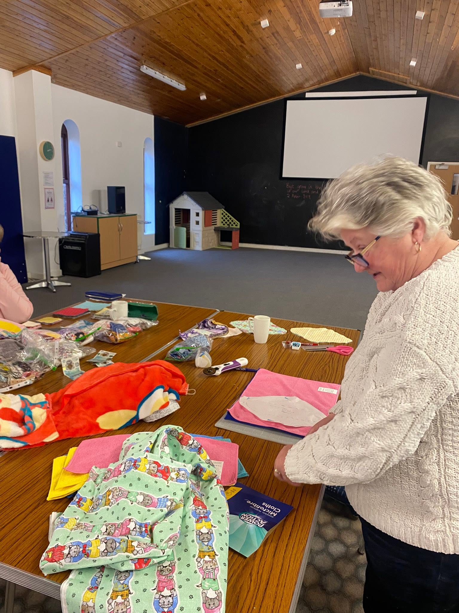 A volunteer cutting out reusable pads from a sewing template at one of our sewing sessions